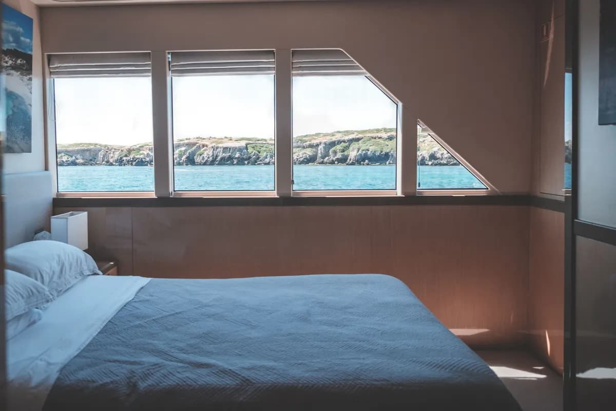 BookNoFees Beispielbild: Helle Bootskabine mit Bett und grossen Fenstern zum Meer