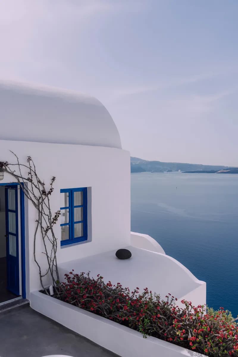 Immagine di esempio BookNoFees: facciata bianca in stile cicladico con dettagli blu e vista sul mare