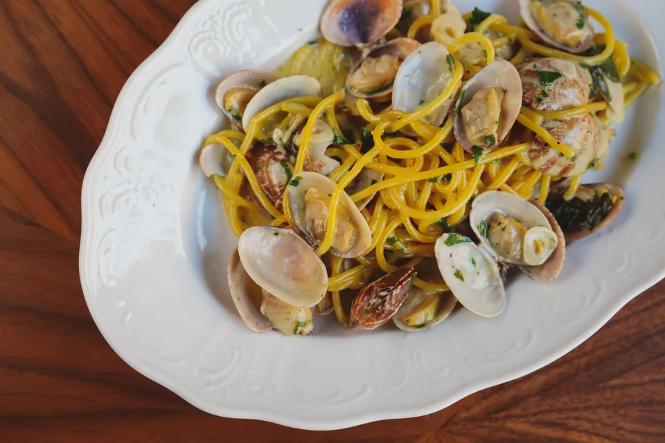 BookNoFees: Beispielfoto: Spaghetti mit Venusmuscheln auf einem weissen Teller