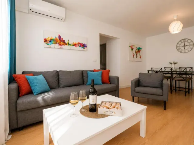 BookNoFees: Ferienwohnung in Jerez De La Frontera – ein Wohnzimmer mit einem Sofa und einem Tisch, auf dem Weingläser stehen, im „Buleria“ in Jerez de la Frontera