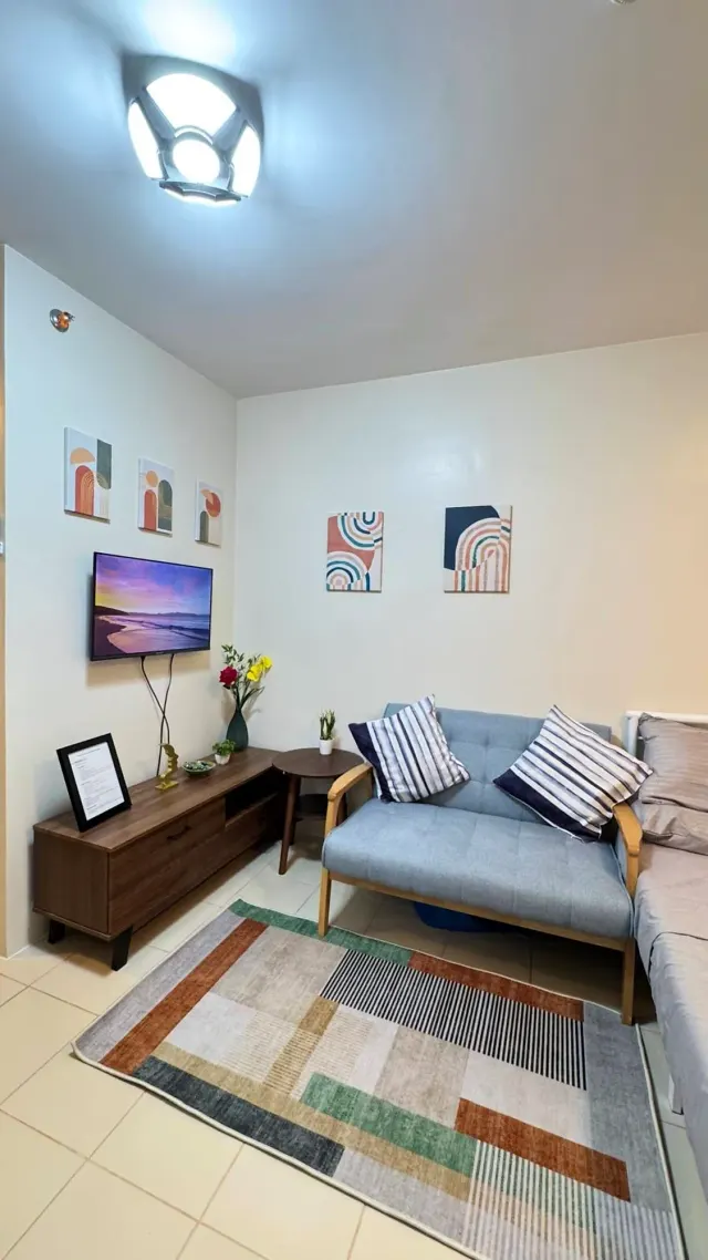 BookNoFees: Ferienwohnung in Davao City, Region Davao, Philippinen – Wohnzimmer mit Sofa, Fernseher und gemustertem Teppich