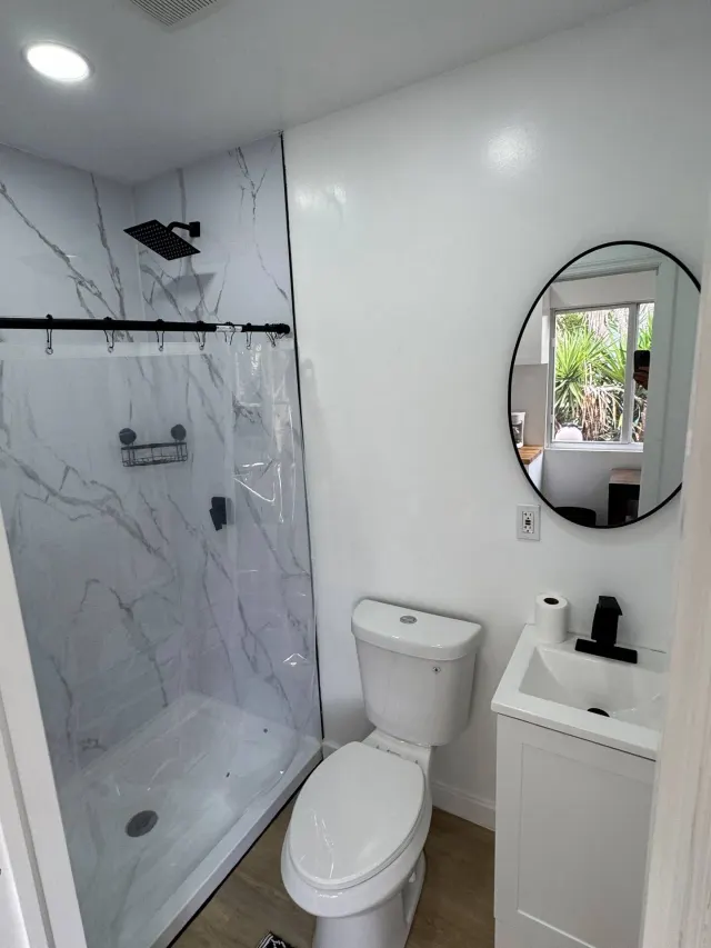 BookNoFees: Ferienwohnung in Cutler Bay, Vereinigte Staaten – Badezimmer mit Dusche in Marmoroptik, Toilette, Waschbecken und rundem Spiegel