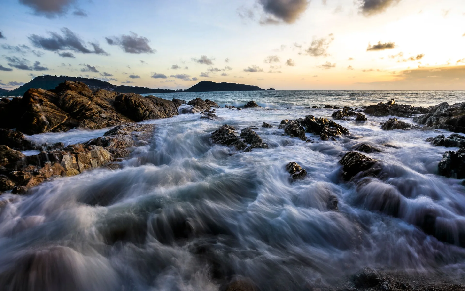 Vagues sur la côte rocheuse de Phuket au coucher du soleil