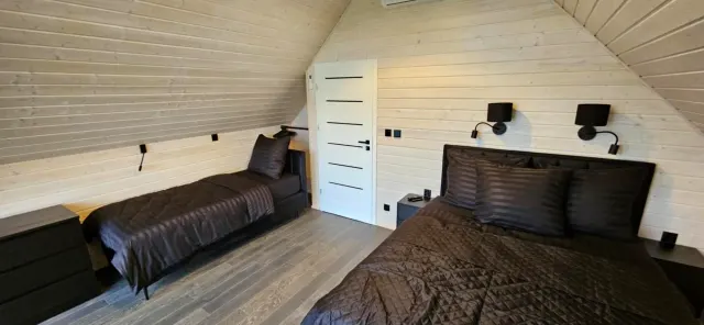 BookNoFees : location de vacances à Rusinowo, Pologne – chambre à coucher avec un lit et deux lampes murales dans l'établissement Black Barn, à Rusinowo