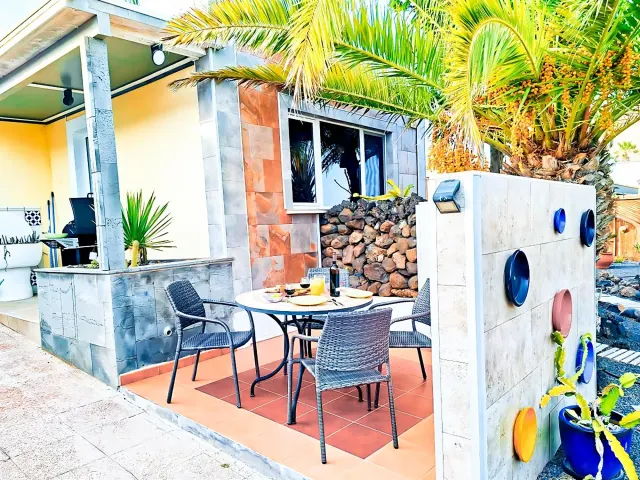 BookNoFees : location de vacances à La Asomada, Espagne – une terrasse avec une table et des chaises dans le logement MADORA-Lanzarote - Tiny House - vue sur la mer, magnifique jardin, emplacement calme, Bodegas, sentiers de randonnée à proximité à La Asomada