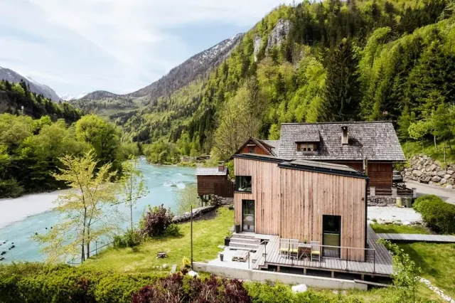 BookNoFees : location de vacances à Hieflau – Vue extérieure d'une maison de vacances en bois, avec la rivière et la montagne en arrière-plan