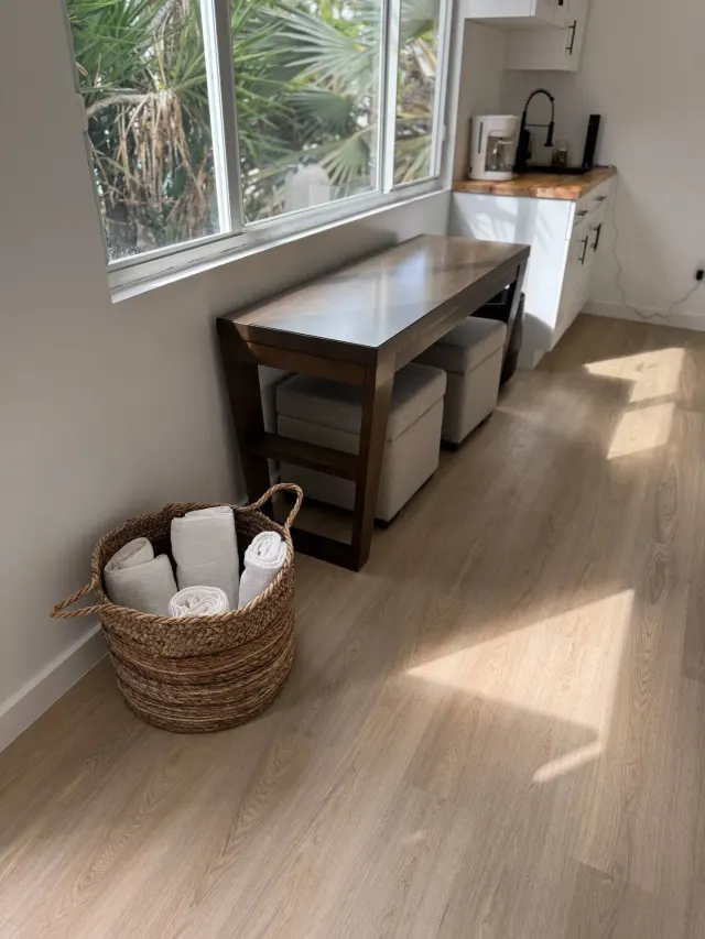 BookNoFees : location de vacances à Cutler Bay, États-Unis – Coin cuisine avec une table en bois, un panier tressé contenant des serviettes et une fenêtre donnant sur des palmiers