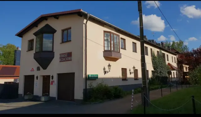 BookNoFees: casa vacanza a Schönfeld, Sassonia, Germania – Esterno di un edificio a due piani con porte da garage, finestre a bovindo e cartello stradale