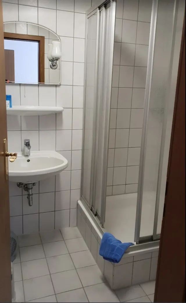 BookNoFees: casa vacanza a Schönfeld, Sassonia, Germania – Bagno con lavandino bianco, vasca da bagno con box doccia e asciugamano blu