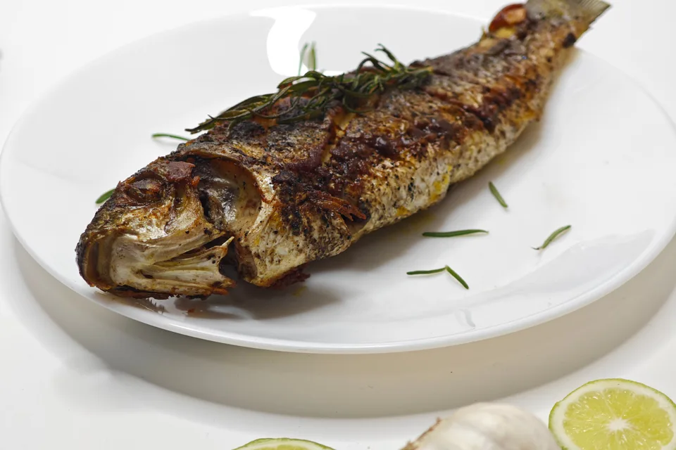 Foto di esempio: Pesce intero alla griglia su un piatto bianco